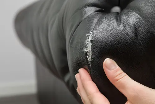 A tear in a black leather couch
